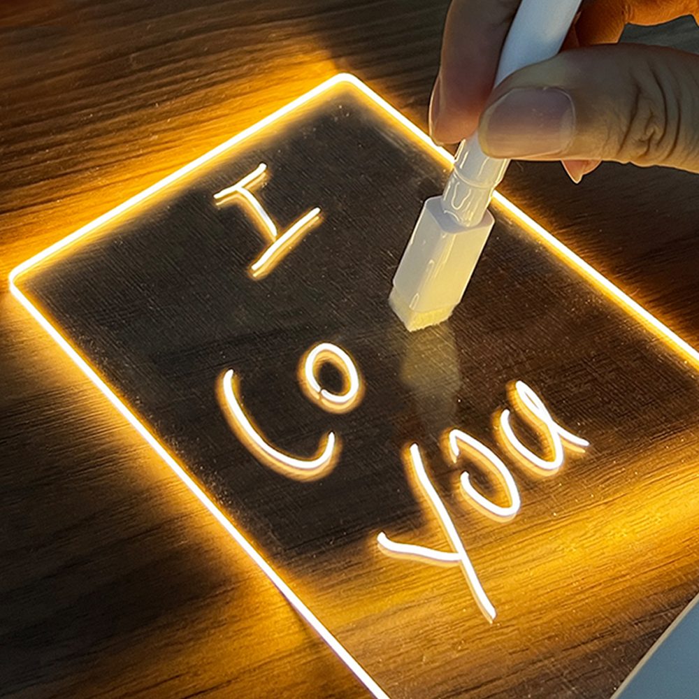 Writing “I love you” with a pen on a glowing Glowboard message board